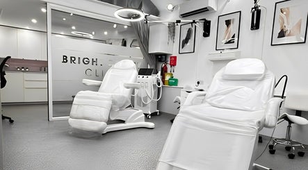 Bright Beauty Clinic's modern treatment room in Great Saxham, England, featuring sleek white chairs.