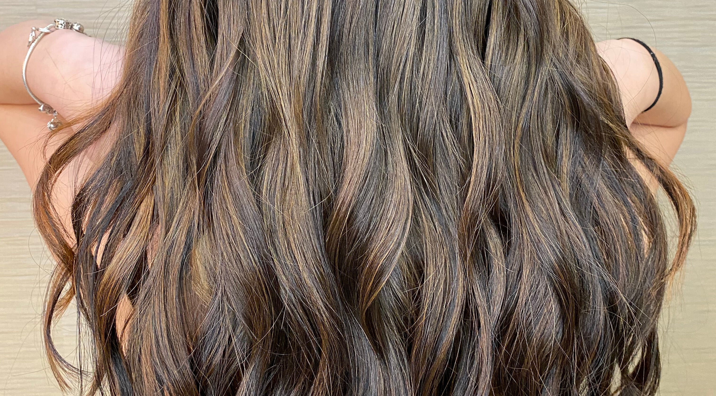 Long, wavy brunette hair styled at Diana's Hair Rhythm Studio, Coral Gables, Florida, US.