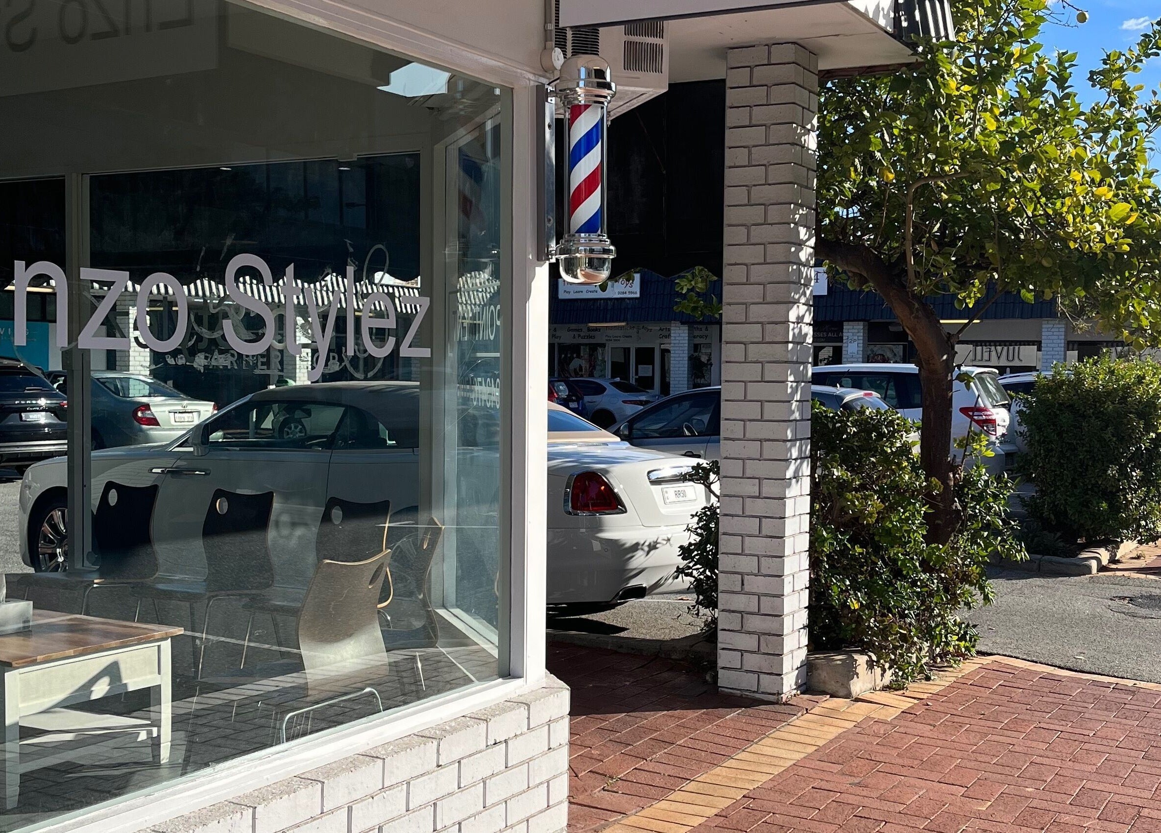 Exterior view of Enzo Stylez salon in Cottesloe, Western Australia, AU, showcasing its stylish entrance and barber pole.