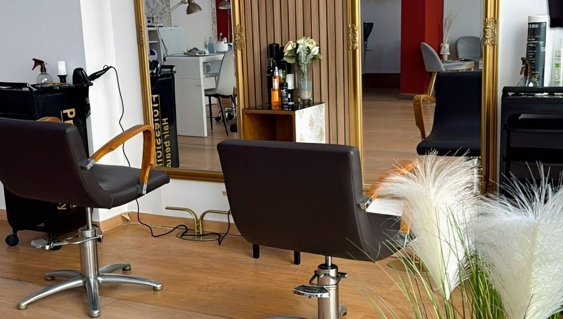 Interior de Mimate Studio en Alacuás, Comunidad Valenciana, ES con sillas de salón y un espejo dorado.