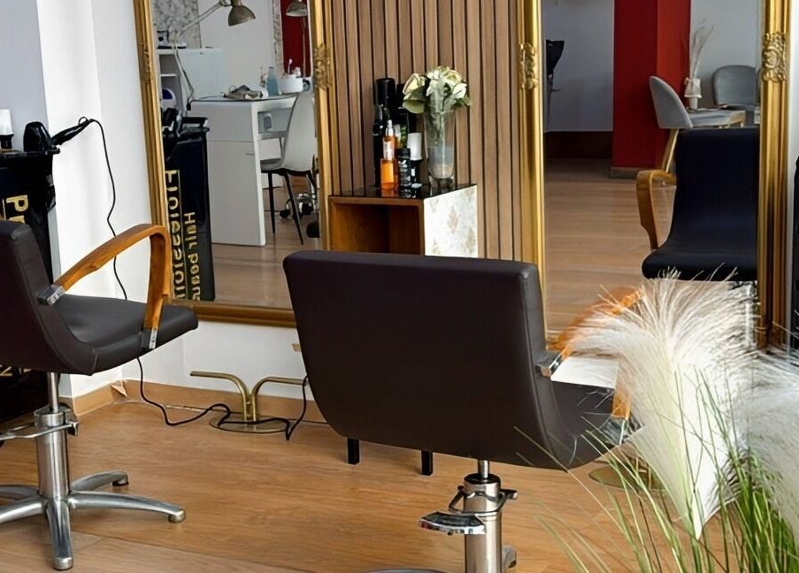 Interior de Mimate Studio en Alacuás, Comunidad Valenciana, ES con sillas de salón y un espejo dorado.