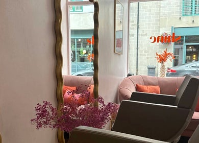 Stylish salon interior at Hairbyntash @ Shine Hair in Dundee, Scotland, GB with plush seating and large mirrors.