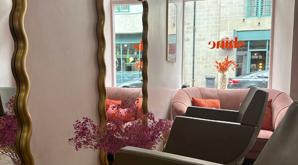 Stylish salon interior at Hairbyntash @ Shine Hair in Dundee, Scotland, GB with plush seating and large mirrors.