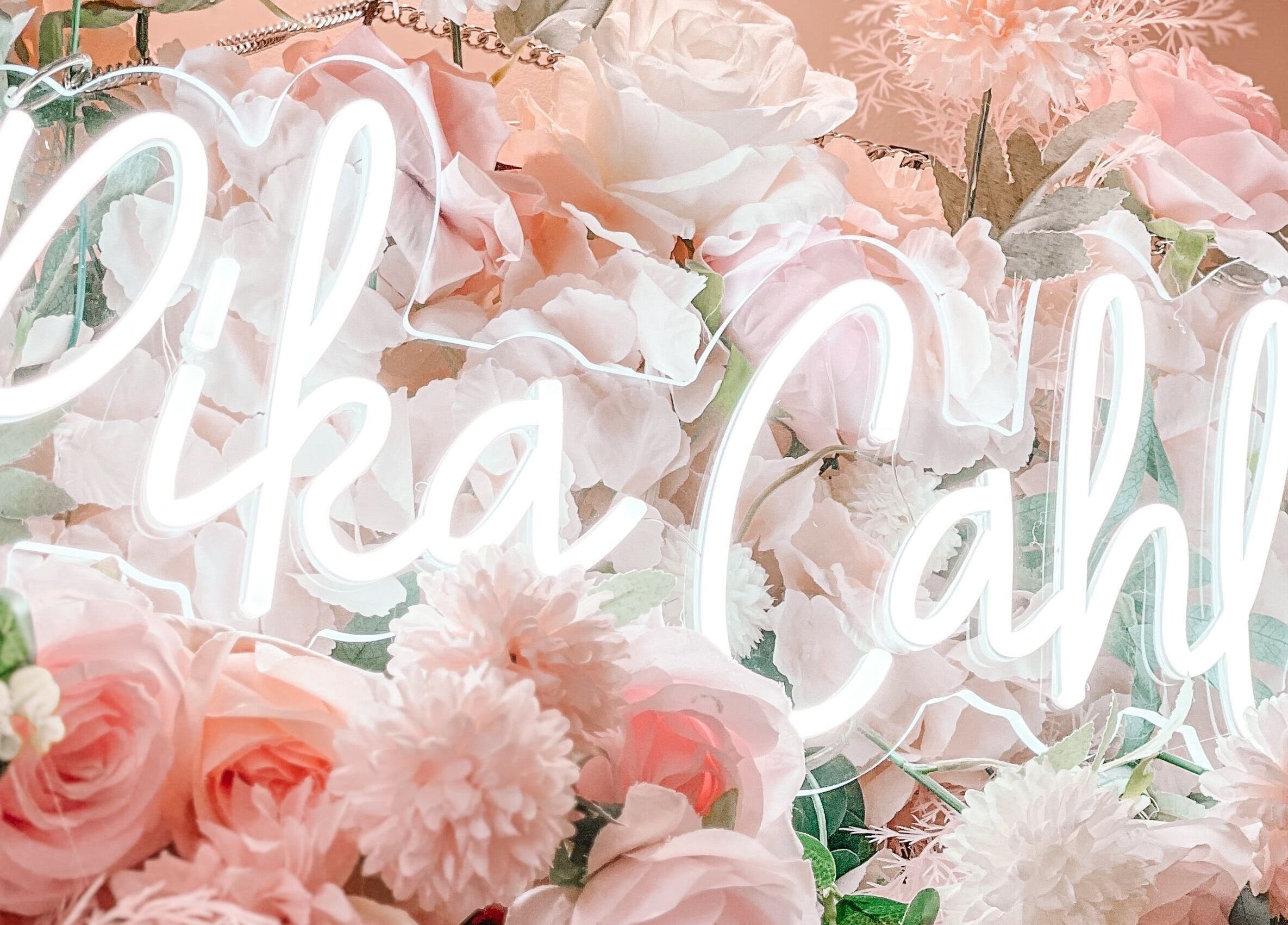 Elegant neon sign nestled among pink roses at Glam Nails And Spa, Bowling Green, Kentucky, US.
