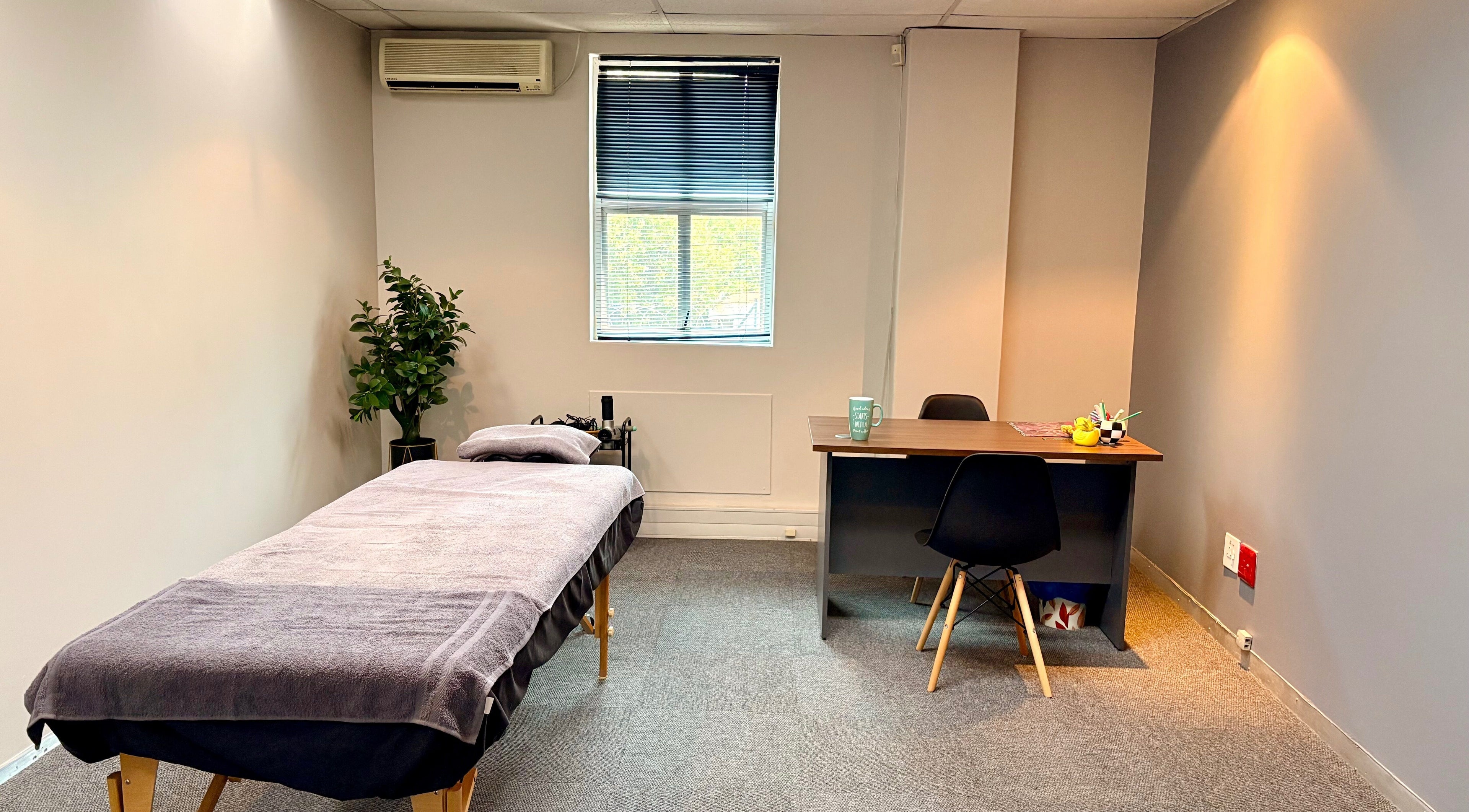 Calming therapy room at LX Sports Therapy, Sandton, Gauteng, ZA, featuring a massage table and desk.
