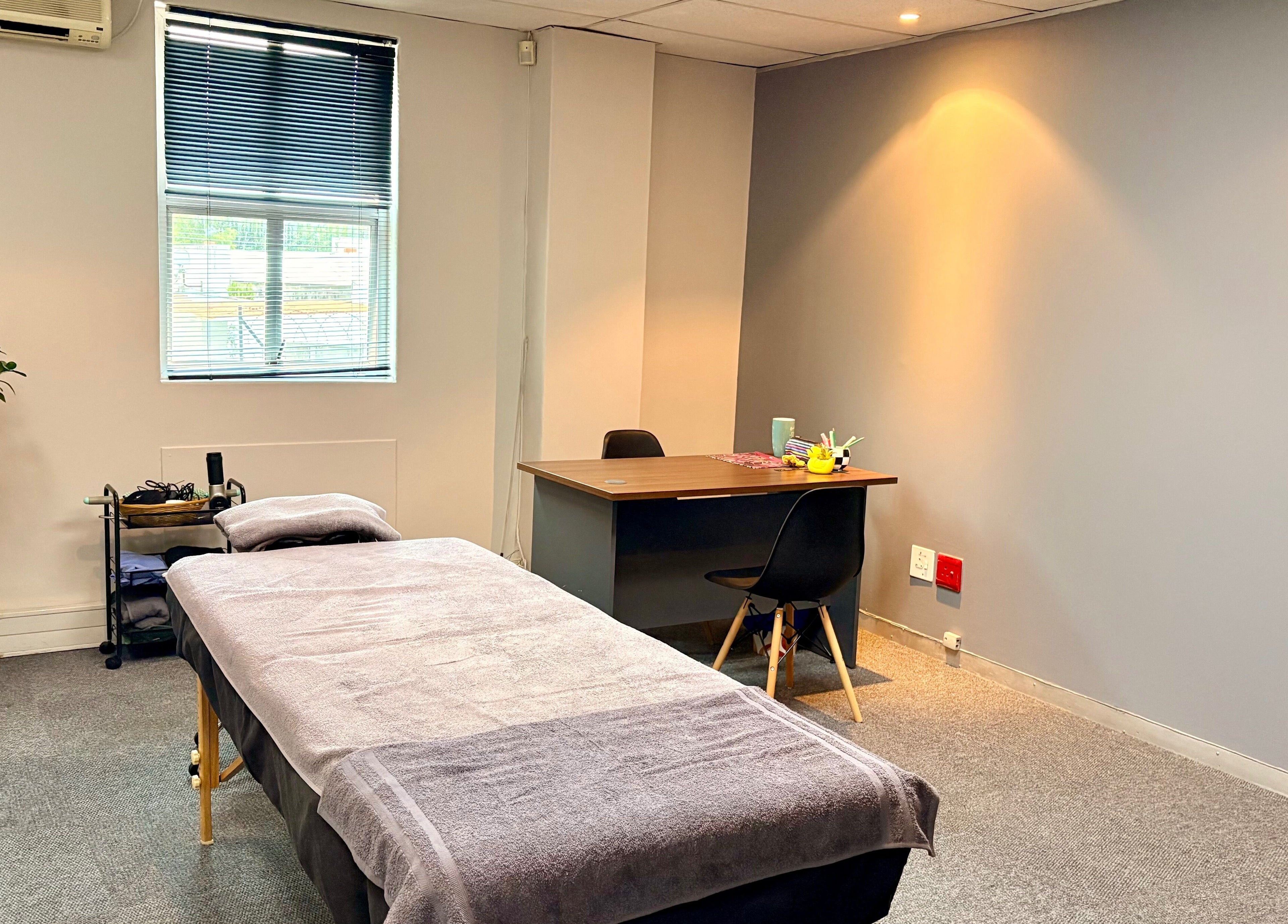 LX Sports Therapy room with massage bed and desk, Sandton, Gauteng, ZA.