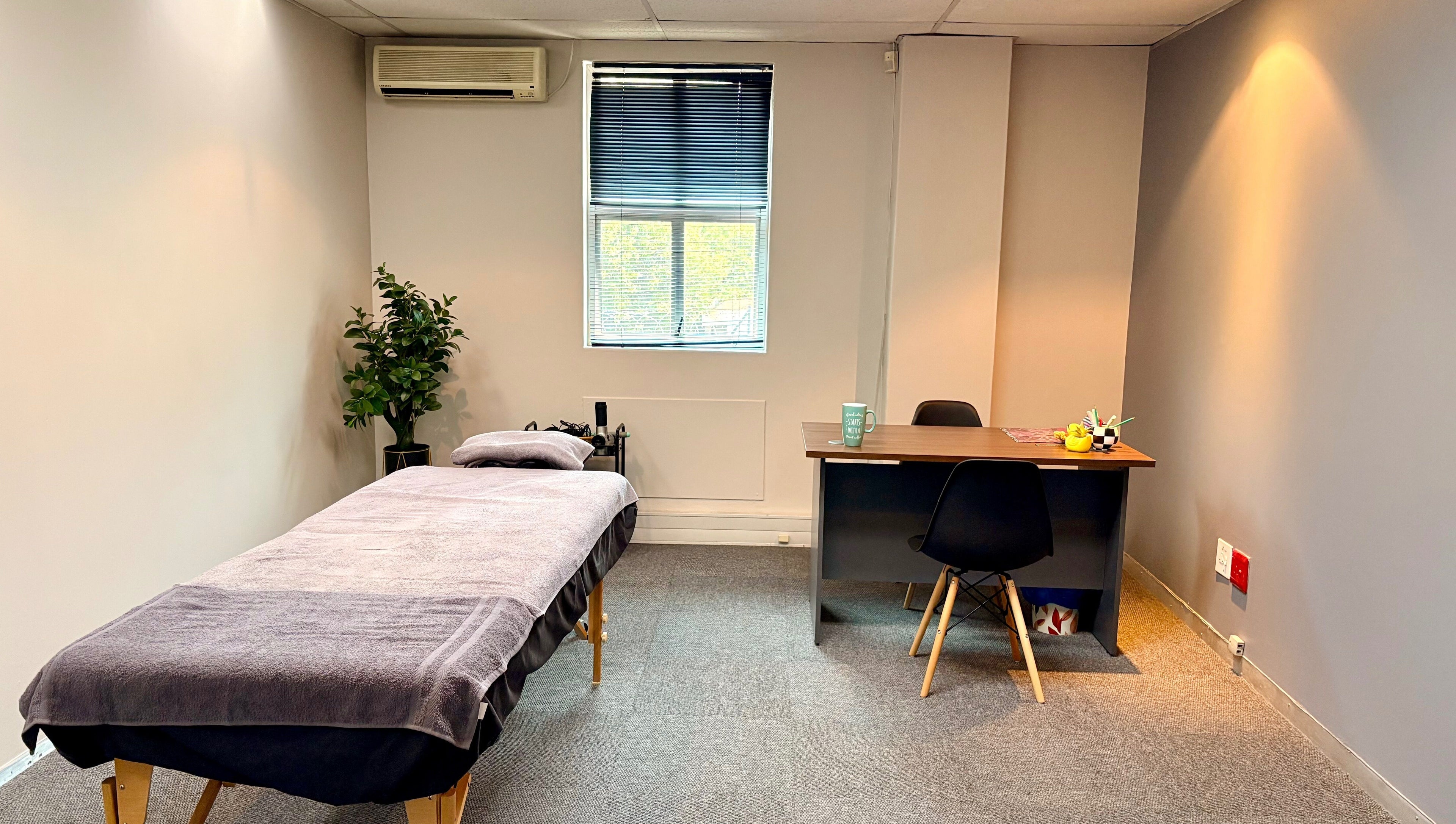 Calm therapy room at LX Sports Therapy in Sandton, Gauteng, ZA, featuring a massage table and office desk.
