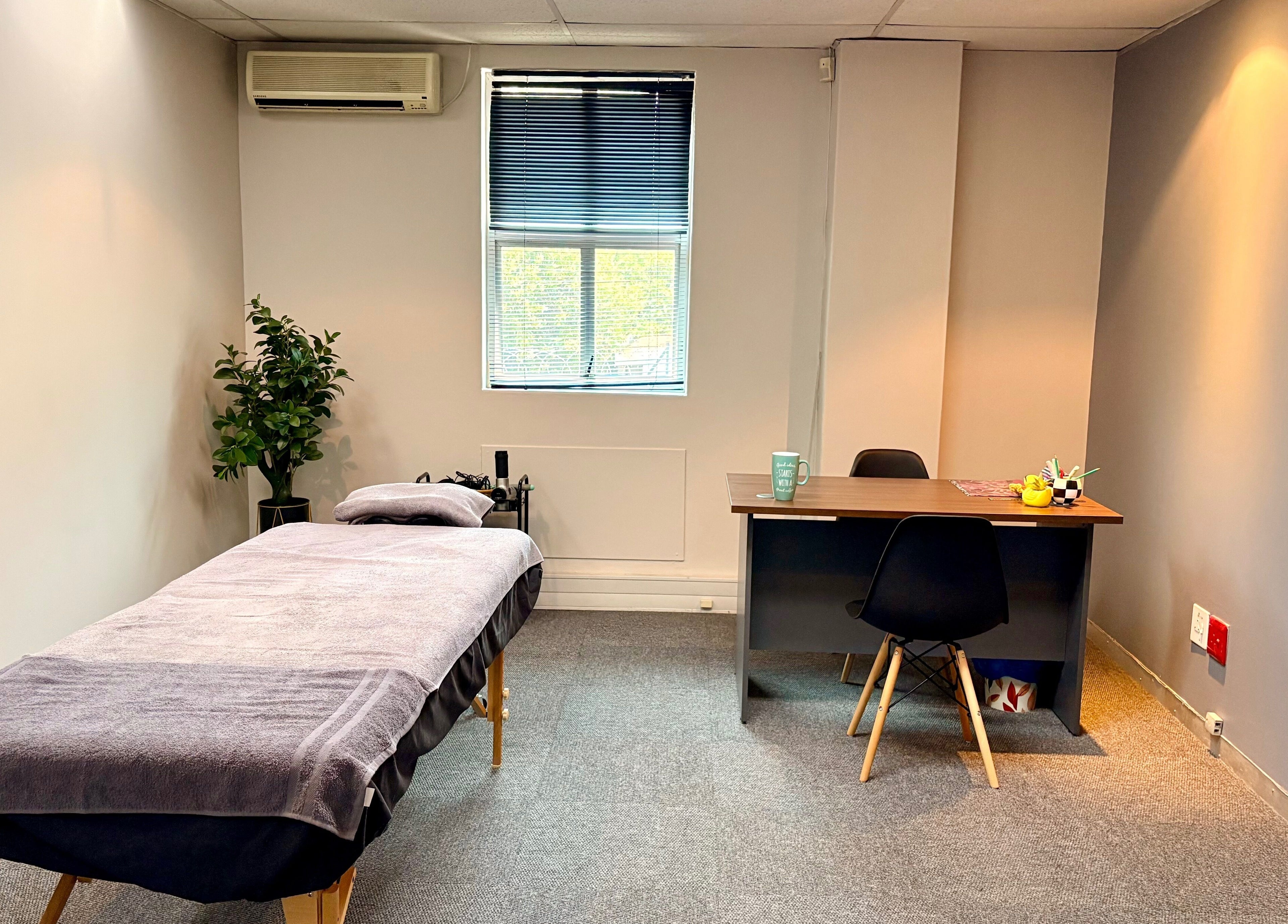 Calm therapy room at LX Sports Therapy in Sandton, Gauteng, ZA, featuring a massage table and office desk.