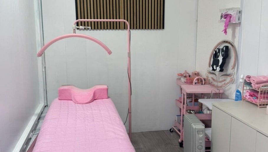 Cozy treatment room at Matylashes and Beauty in London, England, GB with pink decor and a treatment bed.