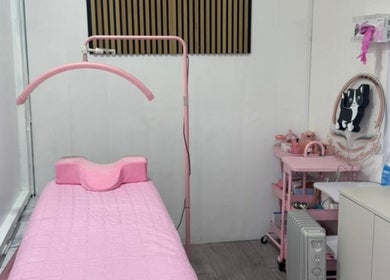 Cozy treatment room at Matylashes and Beauty in London, England, GB with pink decor and a treatment bed.