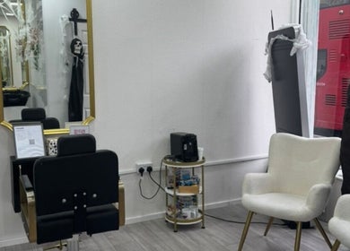 Stylish interior of Matylashes and Beauty, London, England, GB with elegant chairs and large mirror.