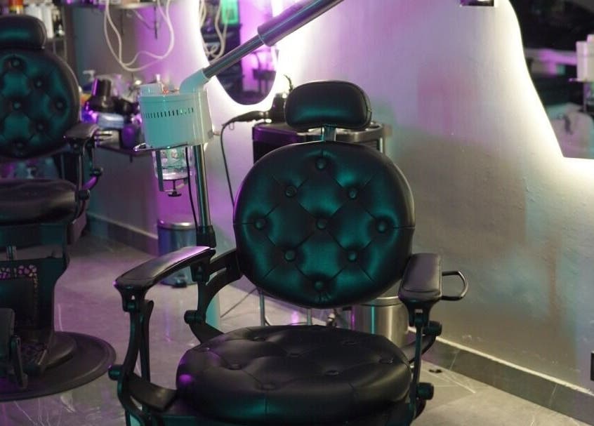 Luxurious barber chairs at Glowing Gents Salon and SPA in Dubai, AE, featuring modern equipment.