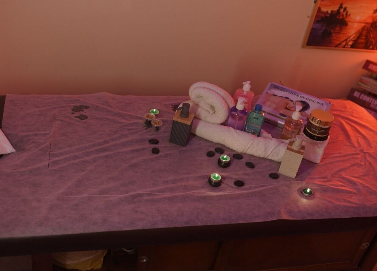 Relaxing spa table setup at Glowing Gents Salon and SPA, Dubai, AE, with candles, oils, and towels.