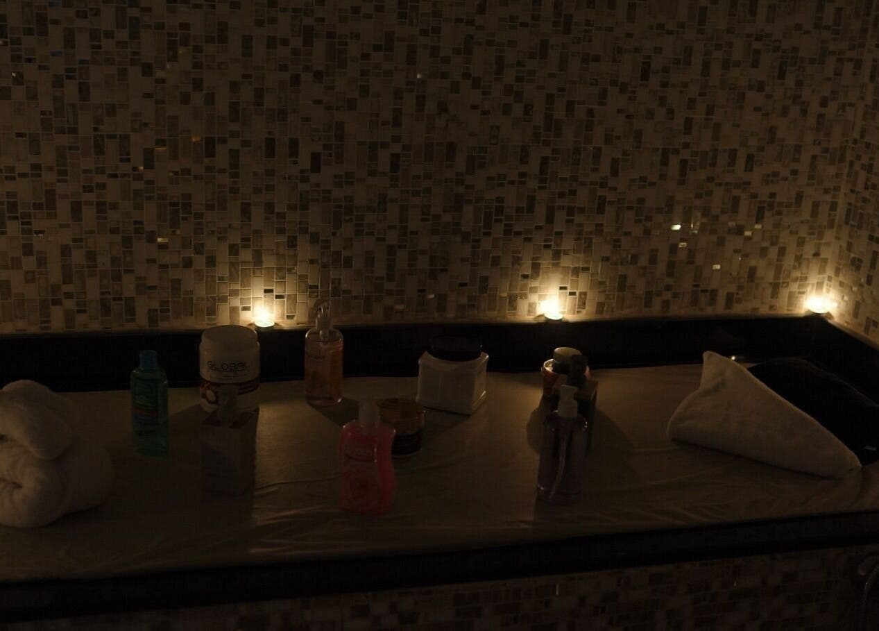 Relaxing spa setup at Glowing Gents Salon and SPA, Dubai, AE with candles and wellness products.