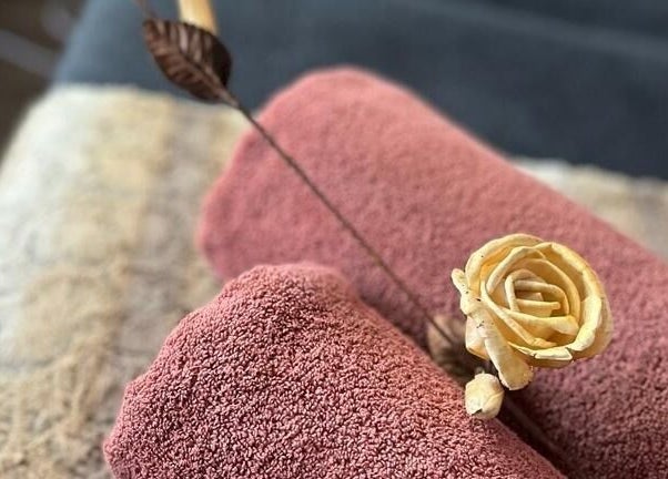 Luxurious towels with a decorative flower at Skin Construct by D, Soweto, Gauteng, ZA.