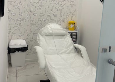 Treatment chair in Malikah Aesthetics Ltd, London, England, GB with artistic wall design.