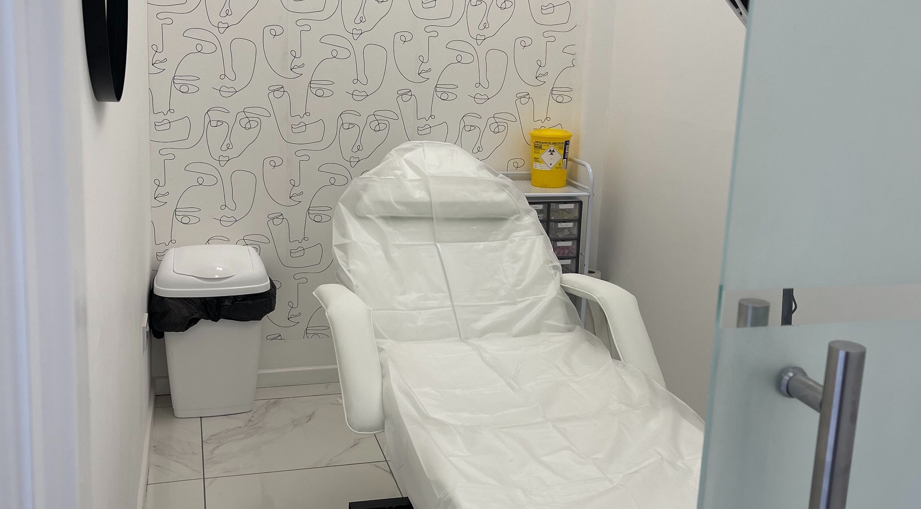 Treatment chair in Malikah Aesthetics Ltd, London, England, GB with artistic wall design.