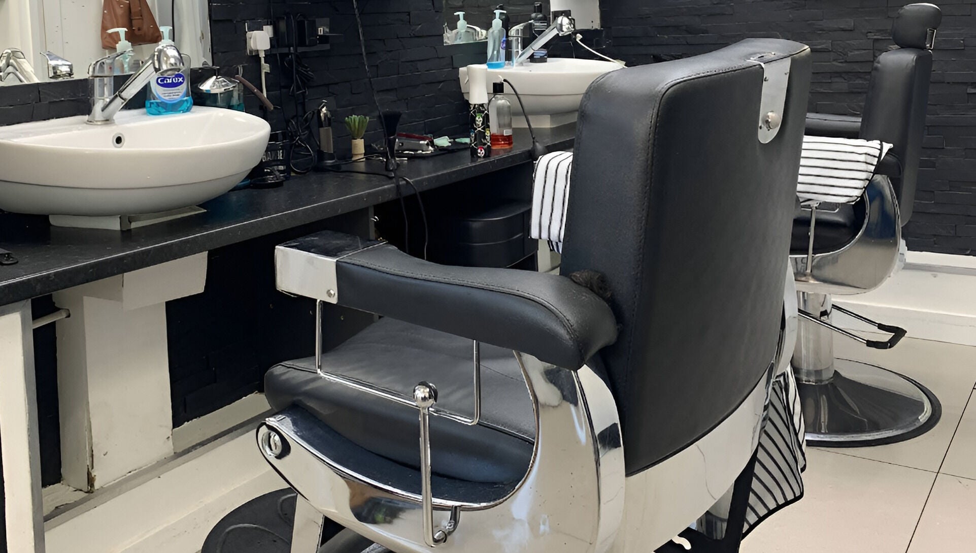 Modern barber chairs and sinks at Andre's Barber Shop in Brighton And Hove, England, GB showcasing sleek design.