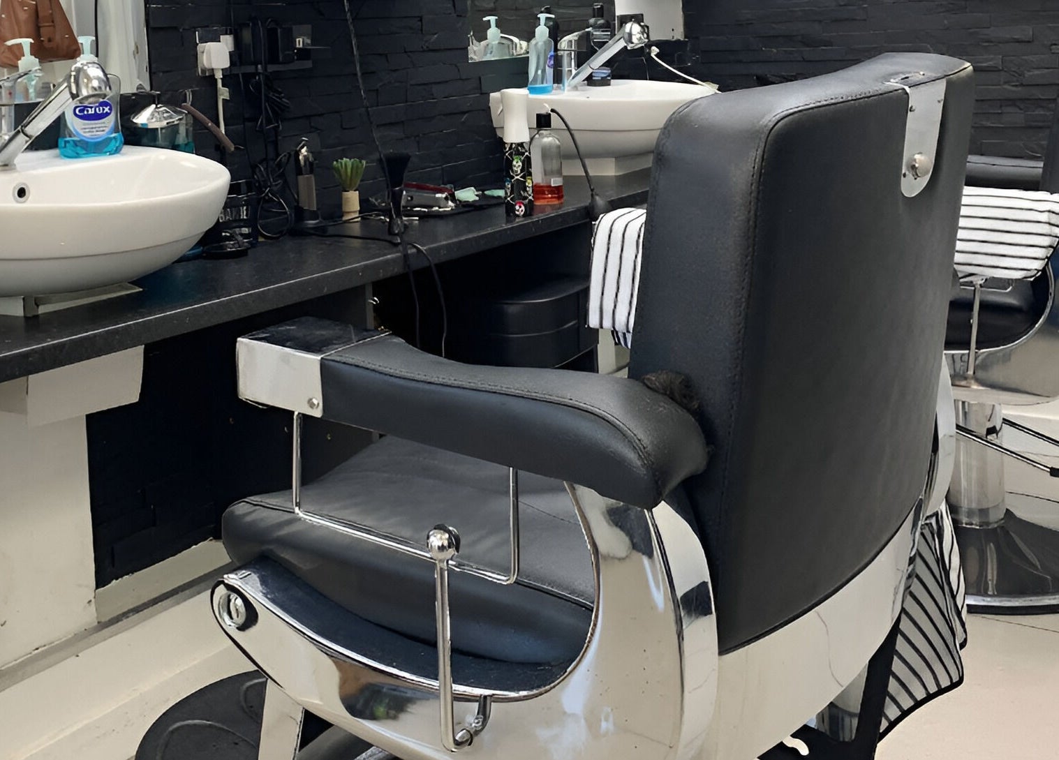 Modern barber chairs and sinks at Andre's Barber Shop in Brighton And Hove, England, GB showcasing sleek design.