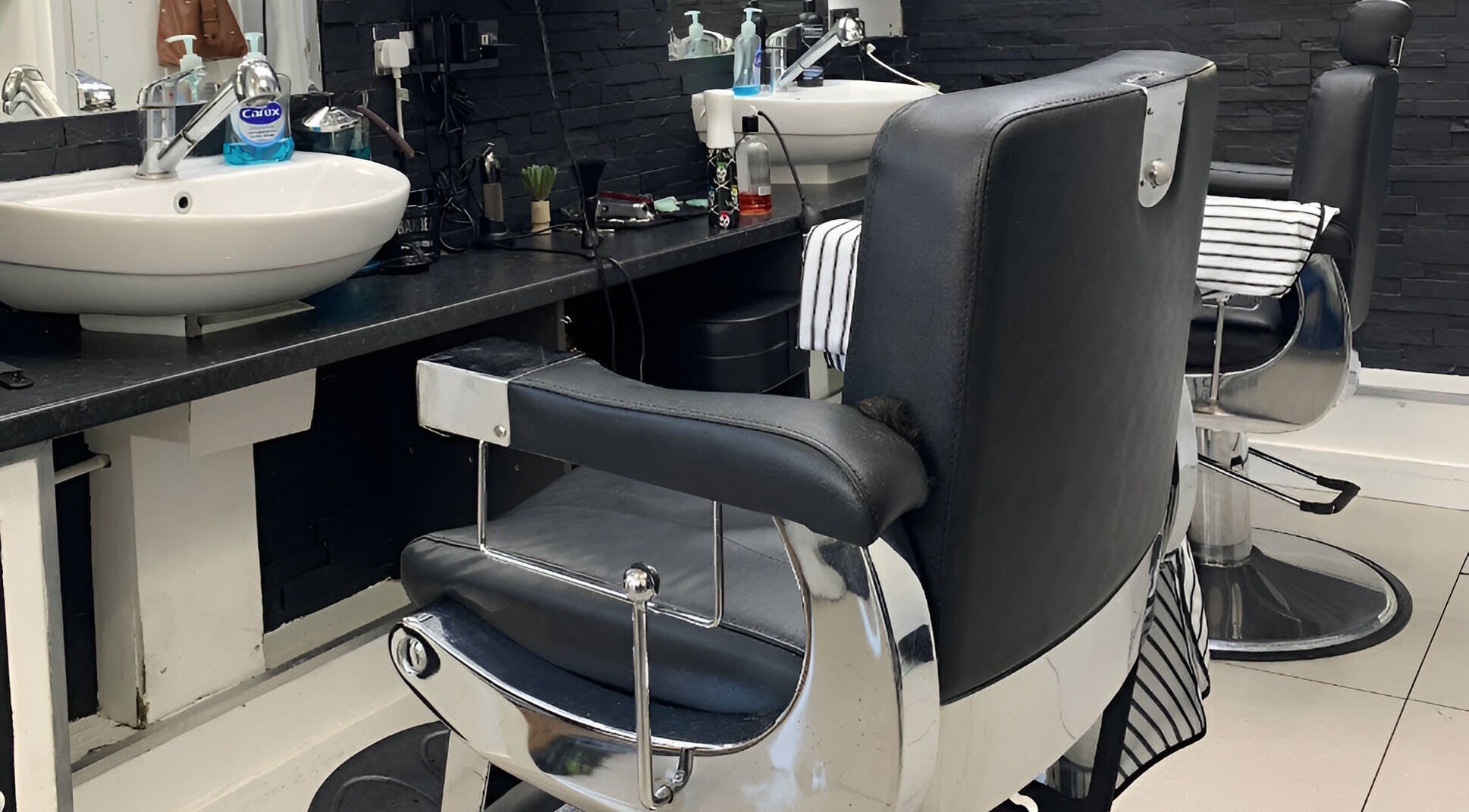 Modern barber chairs and sinks at Andre's Barber Shop in Brighton And Hove, England, GB showcasing sleek design.