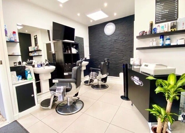 Interior of Andre’s Barber Shop, Brighton And Hove, England, featuring sleek chairs and modern decor.