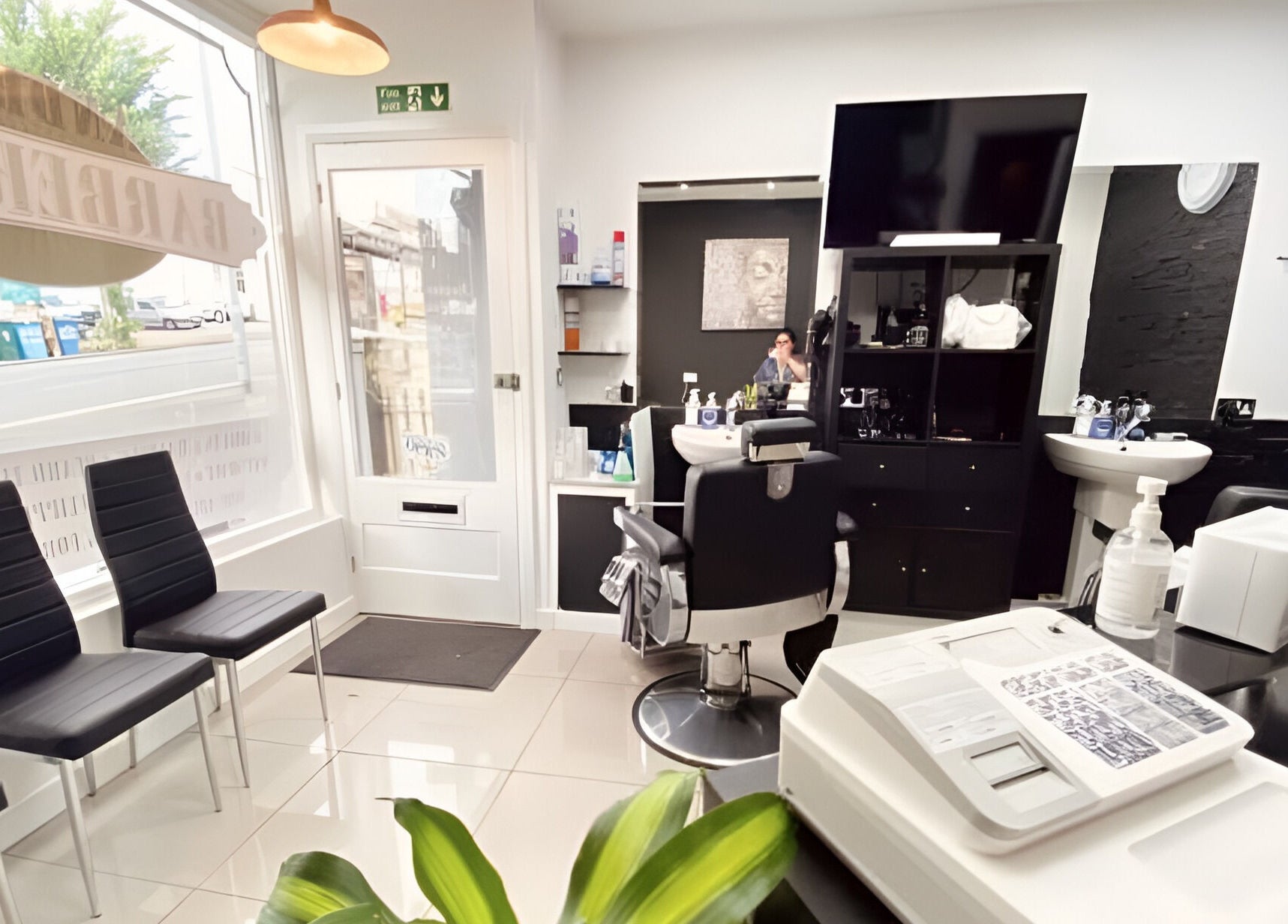 Modern interior of Andre’s Barber Shop in Brighton And Hove, England, showcasing sleek chairs and stylized décor.
