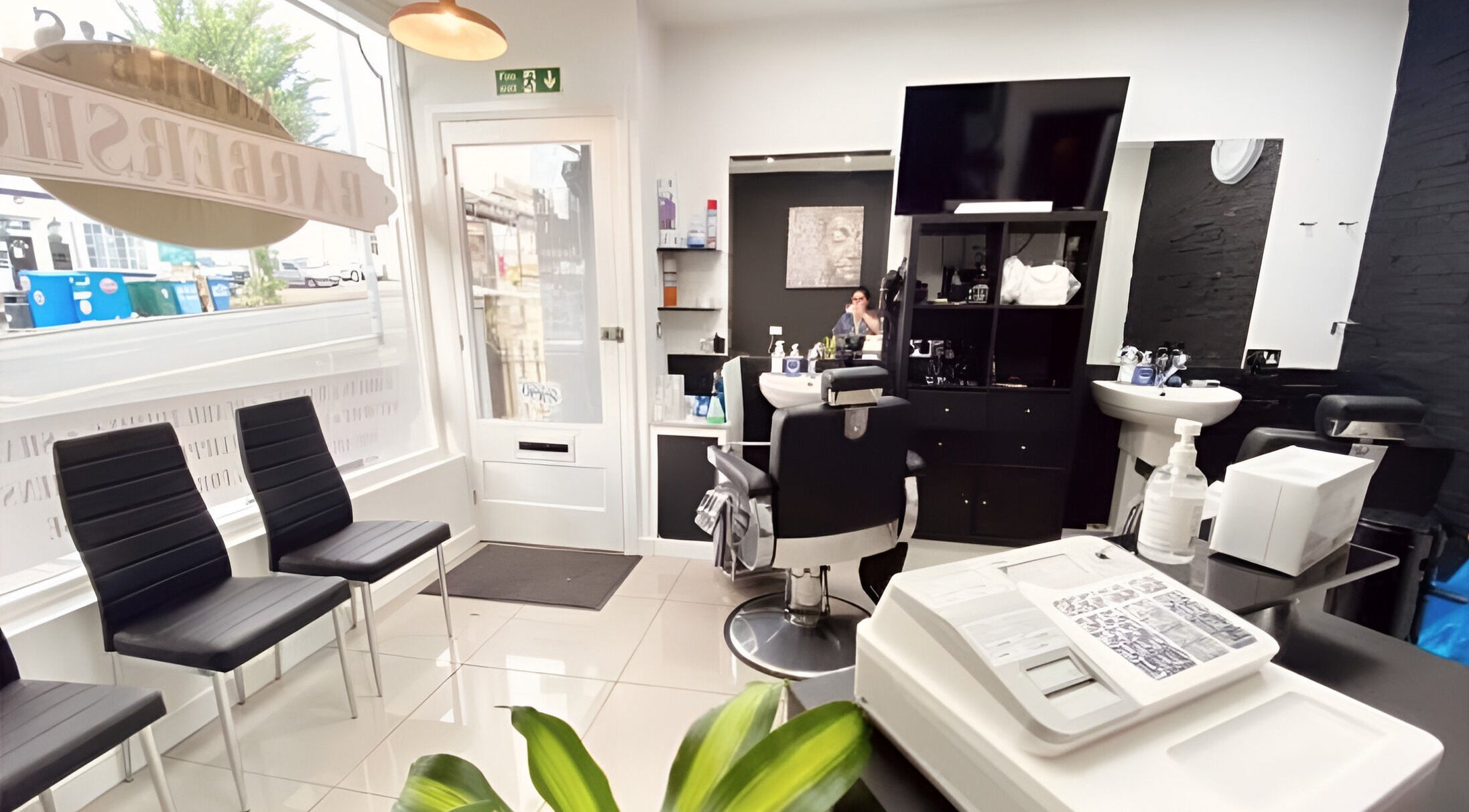 Modern interior of Andre’s Barber Shop in Brighton And Hove, England, showcasing sleek chairs and stylized décor.