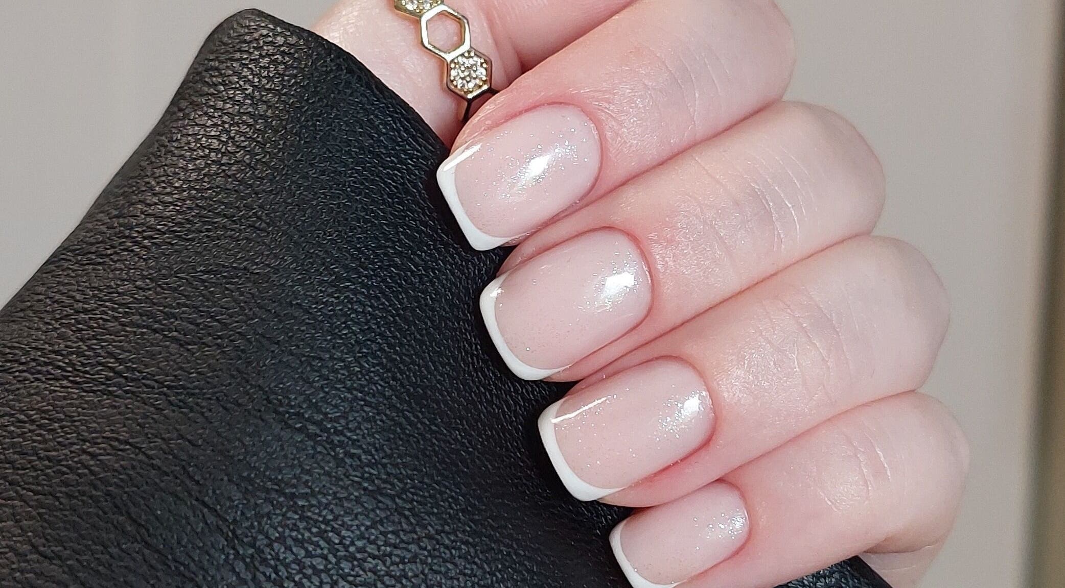 Chic French manicure at Rose & Luxe, Barvas, Scotland, GB. Perfectly polished nails with a touch of sparkle.