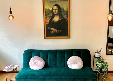 Interior acolhedor do Weilla Nail Studio em Lisboa, Lisboa, PT, com sofá verde elegante e arte icônica.