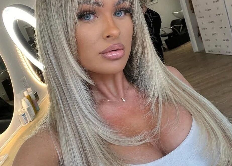 A stylish woman in a salon at XTEND With Style, Fareham, England, GB with a luminous mirror reflection.