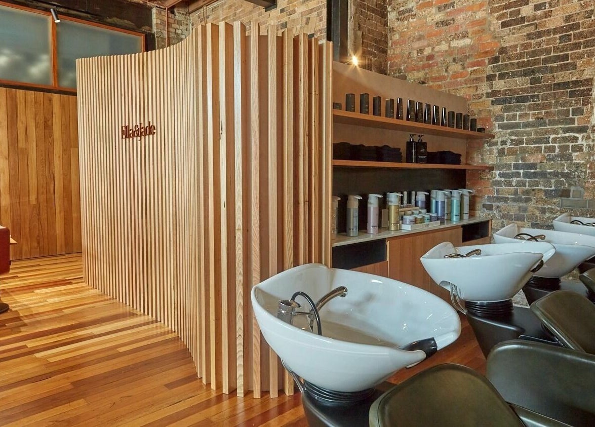 Sleek salon interior at Ella&Jade Woolloongabba, featuring stylish wooden decor and modern wash stations.