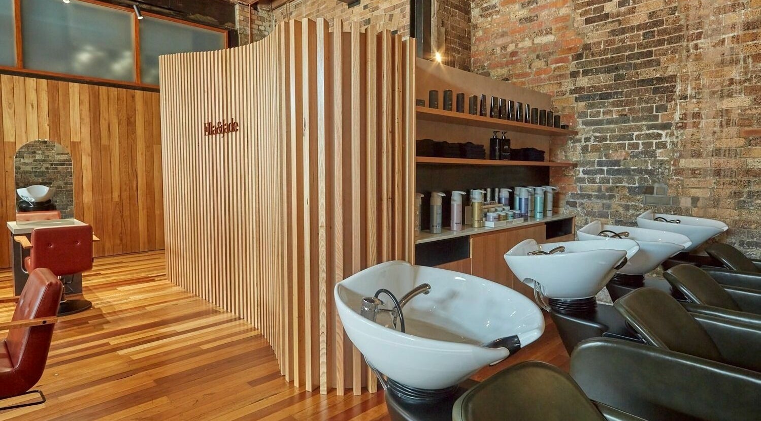Sleek salon interior at Ella&Jade Woolloongabba, featuring stylish wooden decor and modern wash stations.