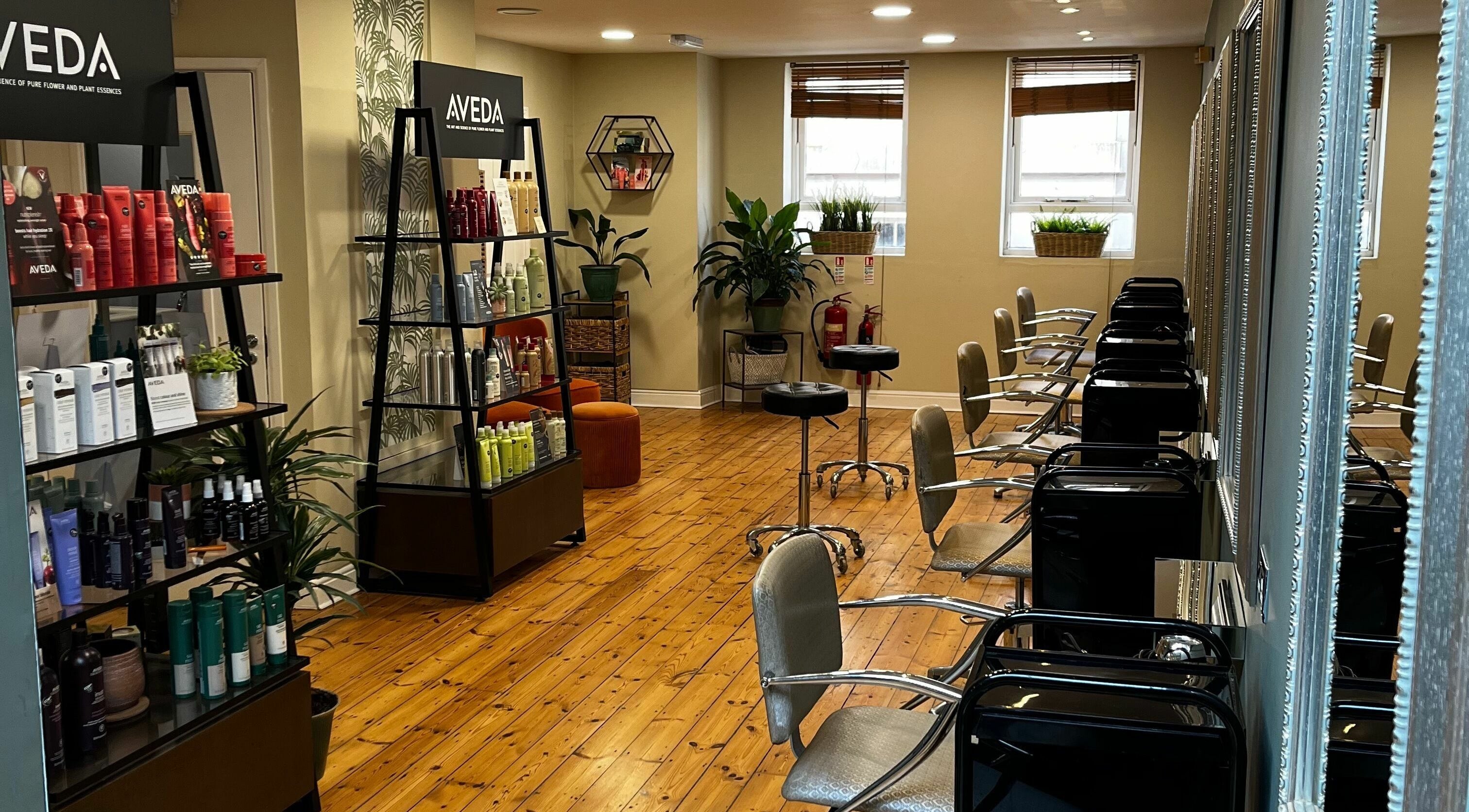 Modern salon interior at Head Hair and Beauty, Exeter, England, GB, showcasing stylish chairs and premium products.