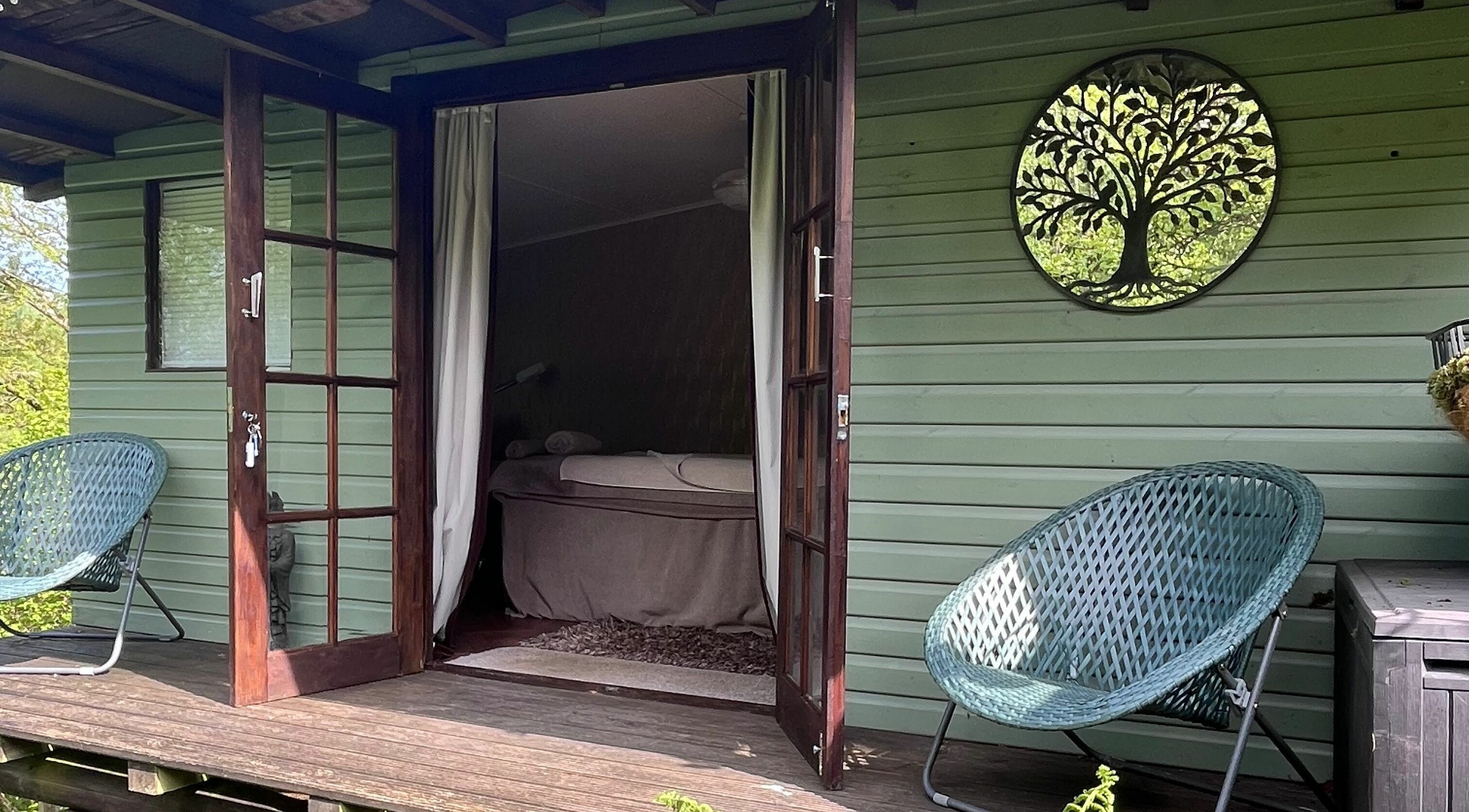 Relaxing treatment room at Tranquility Treatment Room in Whitworth, England with open doors and nature views.