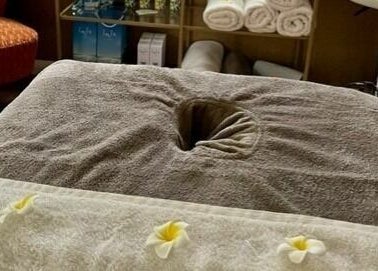 Cozy massage table in Tranquility Treatment Room, Whitworth, England, GB, adorned with fresh towels.