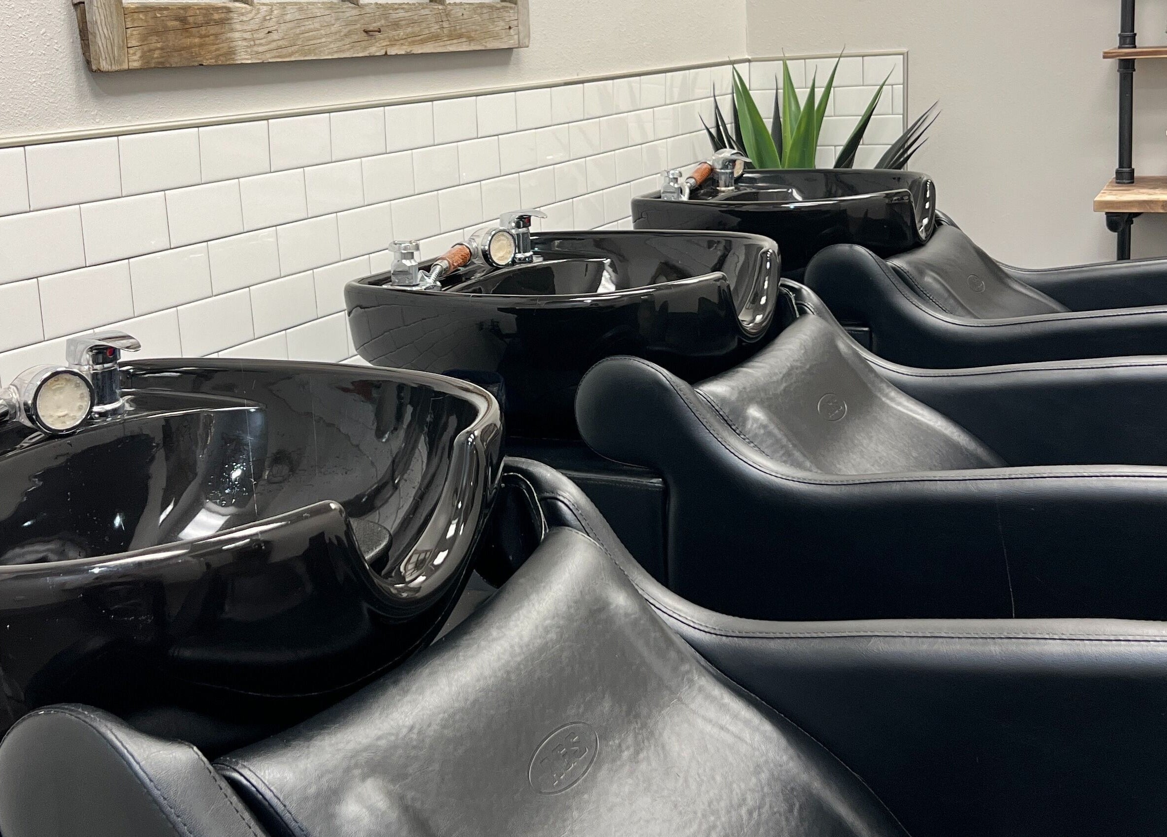 Modern black wash stations at La Belle Vie Salon and Spa, Pleasant Grove, Utah, US, featuring sleek design.