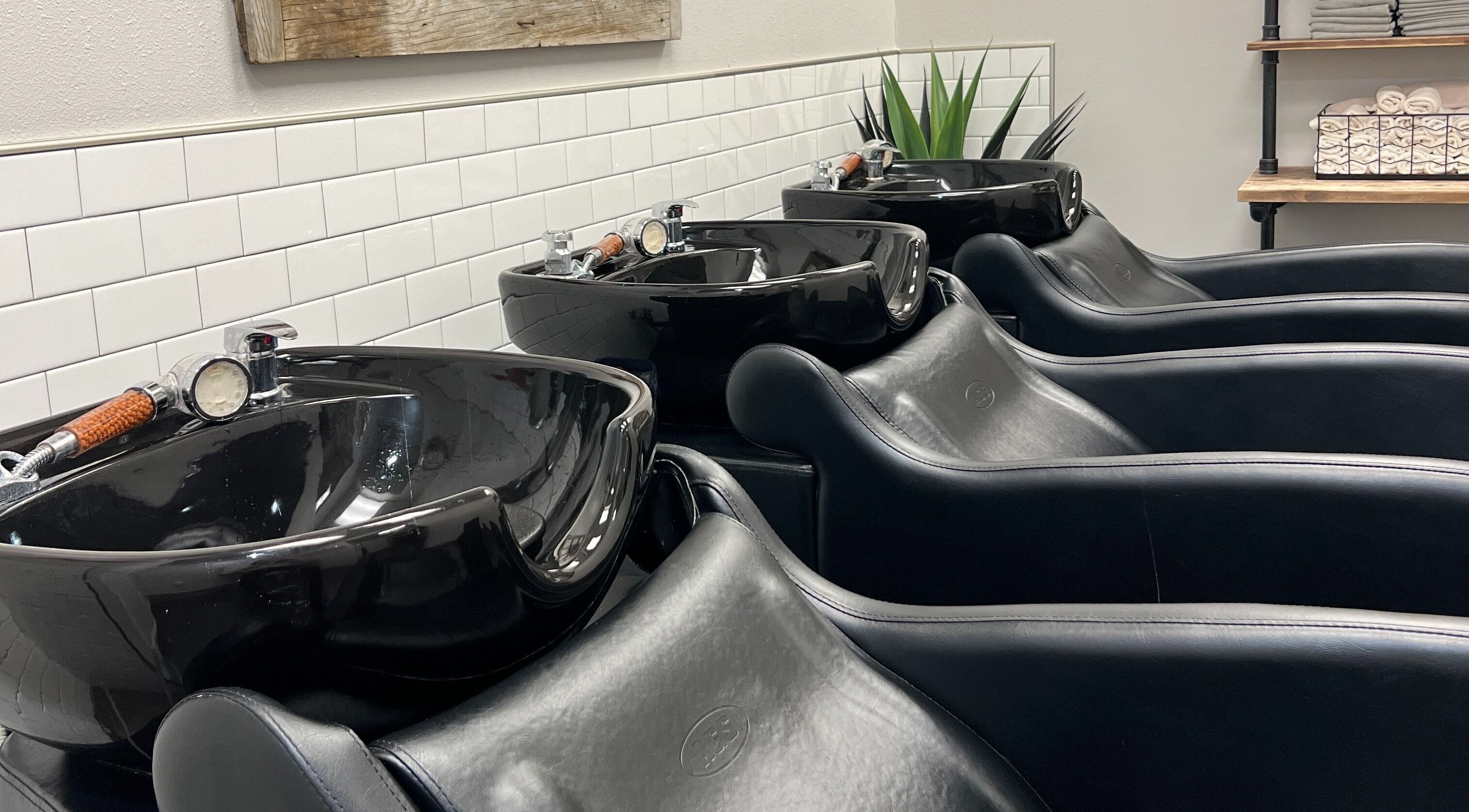 Modern black wash stations at La Belle Vie Salon and Spa, Pleasant Grove, Utah, US, featuring sleek design.