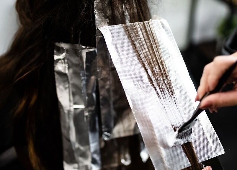 Hair coloring process at West Ivie Collective Beauty Lounge in Lindon, Utah, showcasing expert touch with foils.