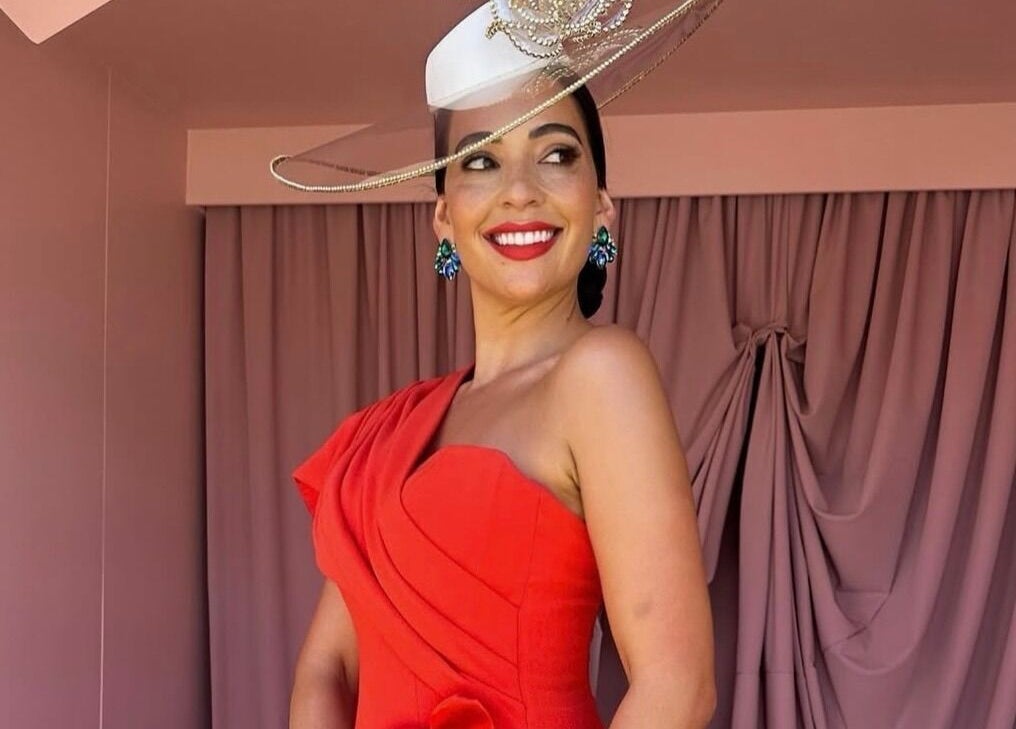 Smiling woman in vibrant racewear at Spring Racing Carnival Bookings - PRAHRAN, Prahran, Victoria, AU.