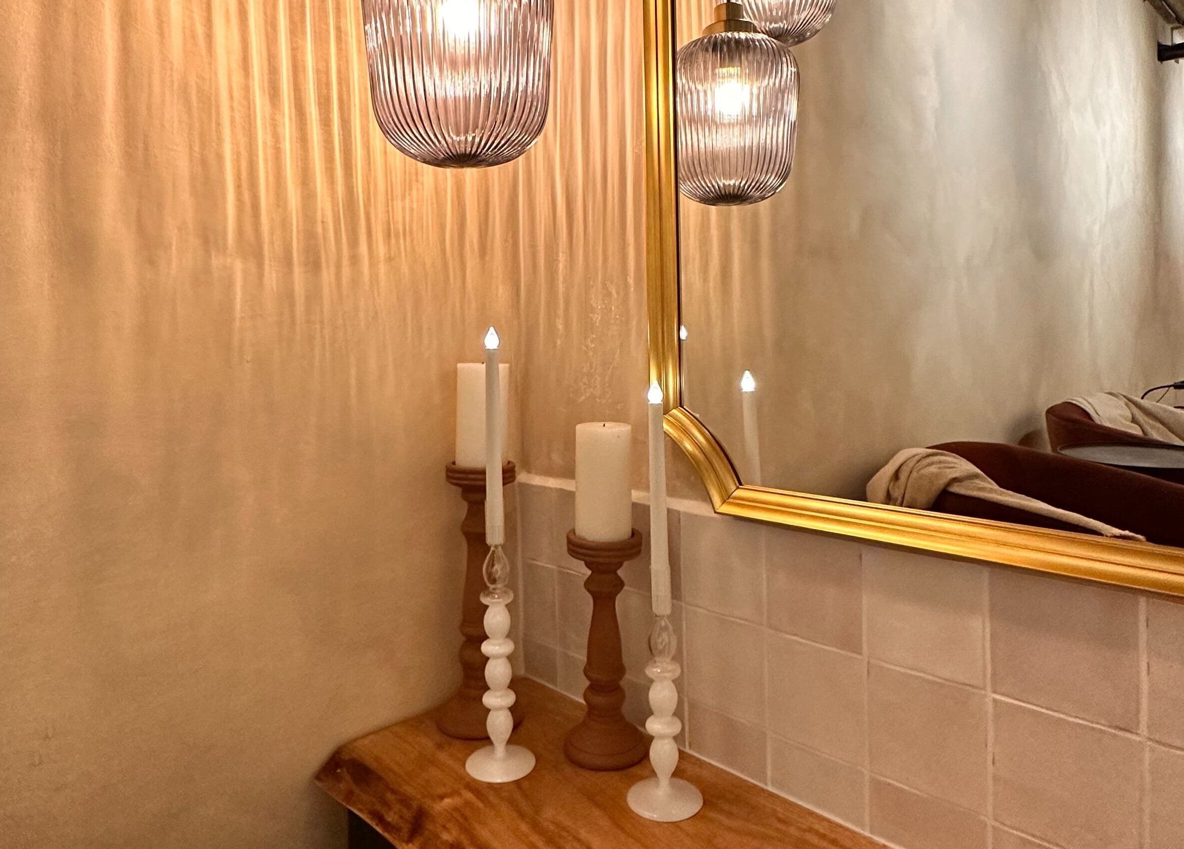 Decoración elegante en Magnolia Salon Studio, San Juan, con candelabros y espejo dorado.