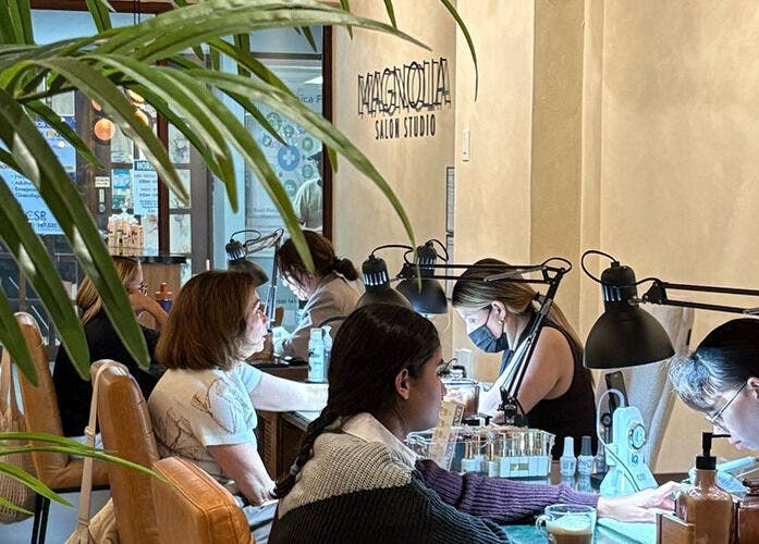 Clientes recibiendo manicuras en Magnolia Salon Studio, San Juan, San Juan, PR, con un ambiente acogedor.