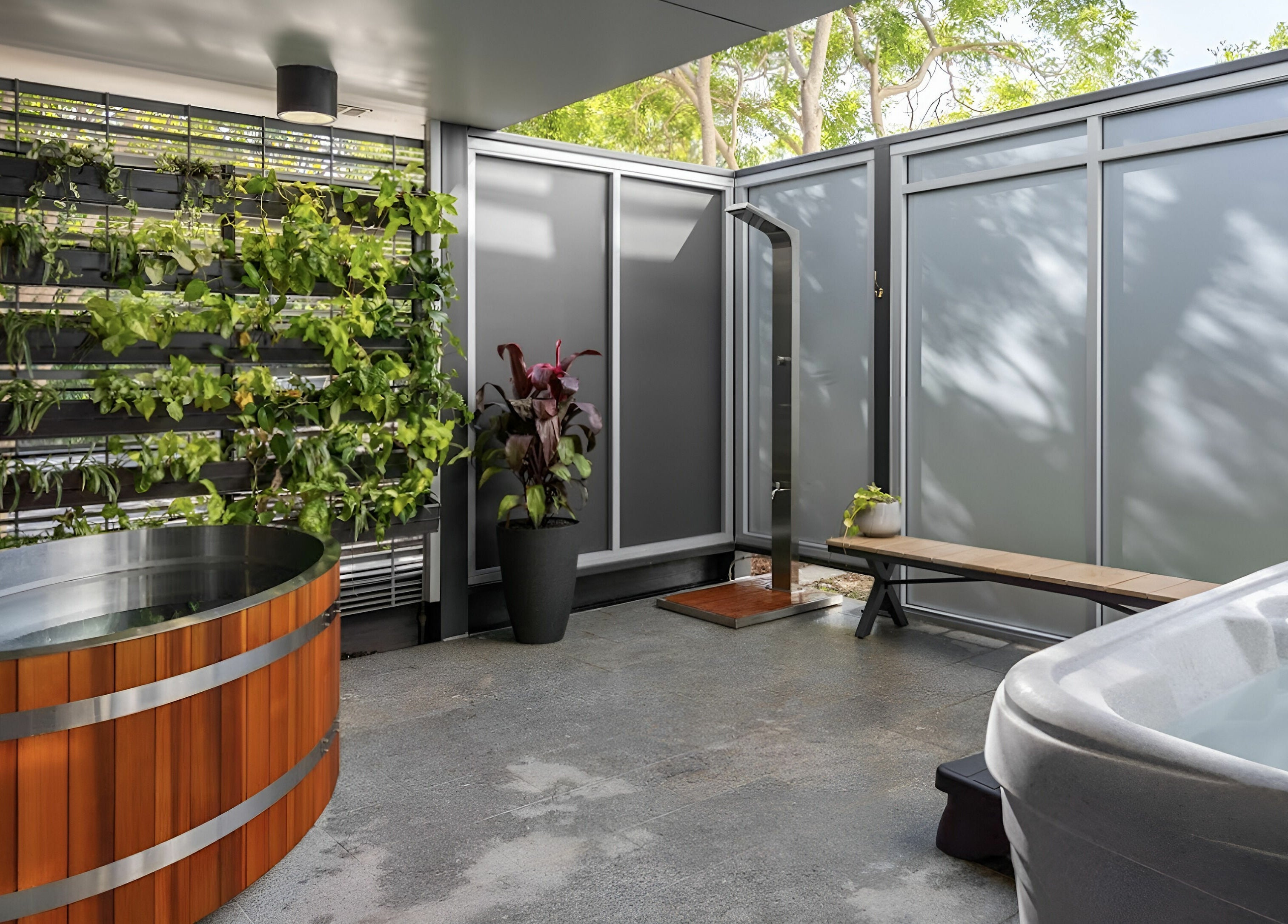 Modern spa area at Recovery Room Seaspray, Zilzie, Queensland, AU, featuring a hot tub and lush greenery.