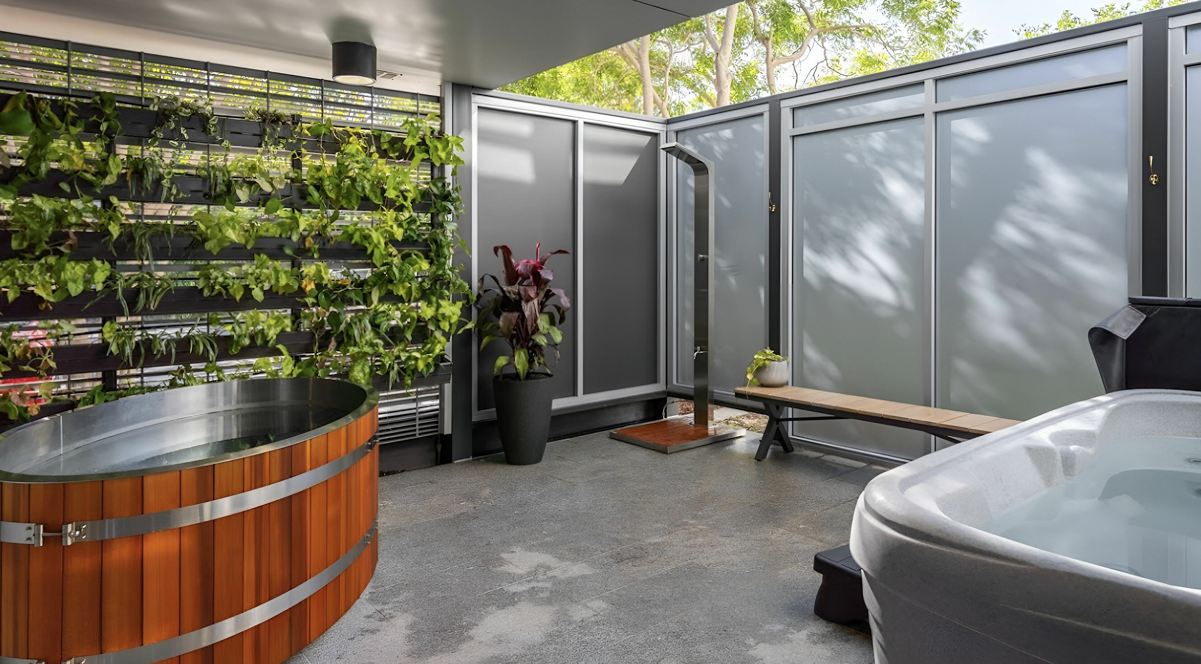 Modern spa area at Recovery Room Seaspray, Zilzie, Queensland, AU, featuring a hot tub and lush greenery.