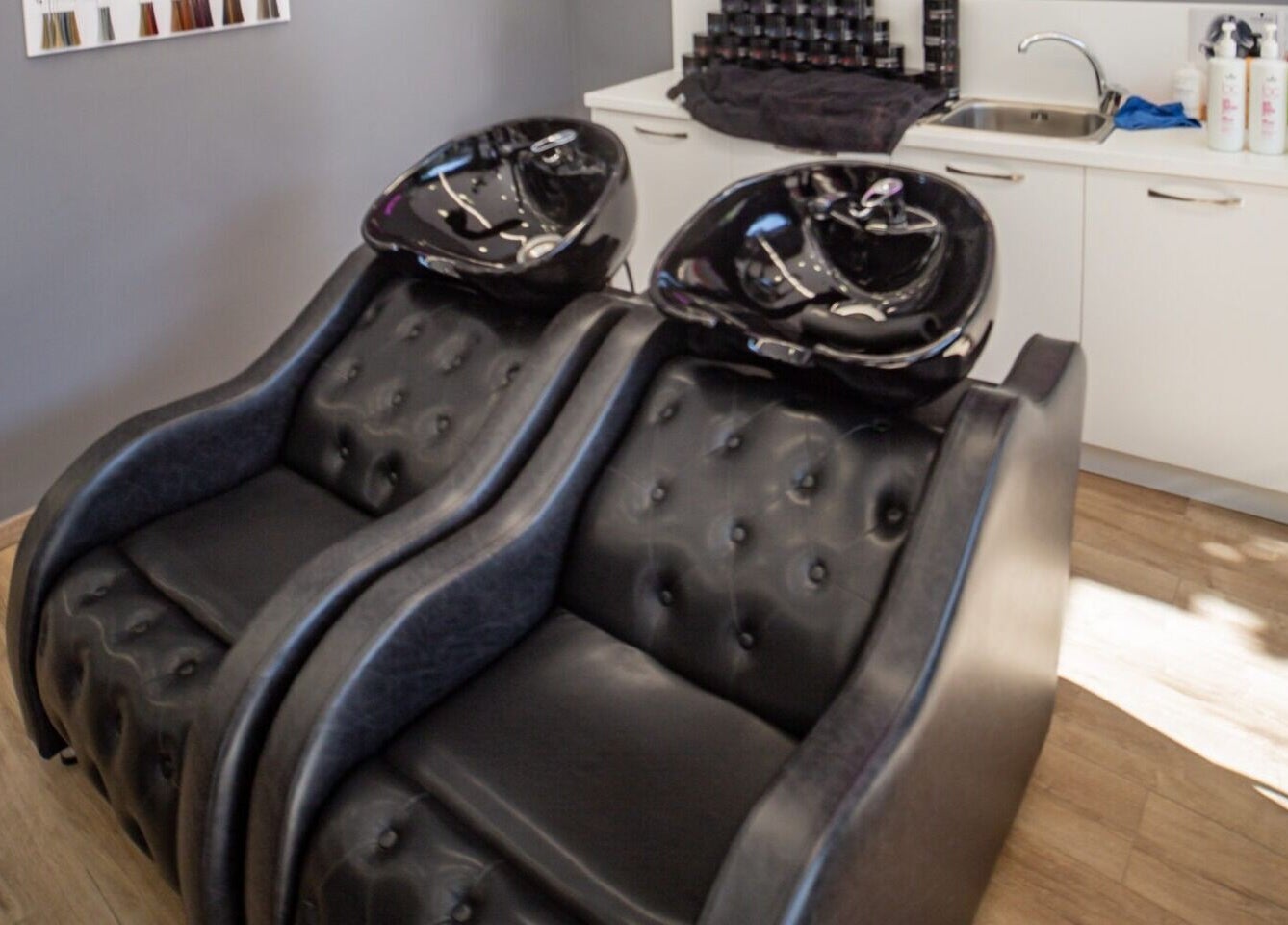 Μαύροι λουτήρες στο σαλόνι Medusa Evosmos, Εύοσμος, GR, προσφέροντας άνεση και πολυτέλεια για περιποίηση μαλλιών.