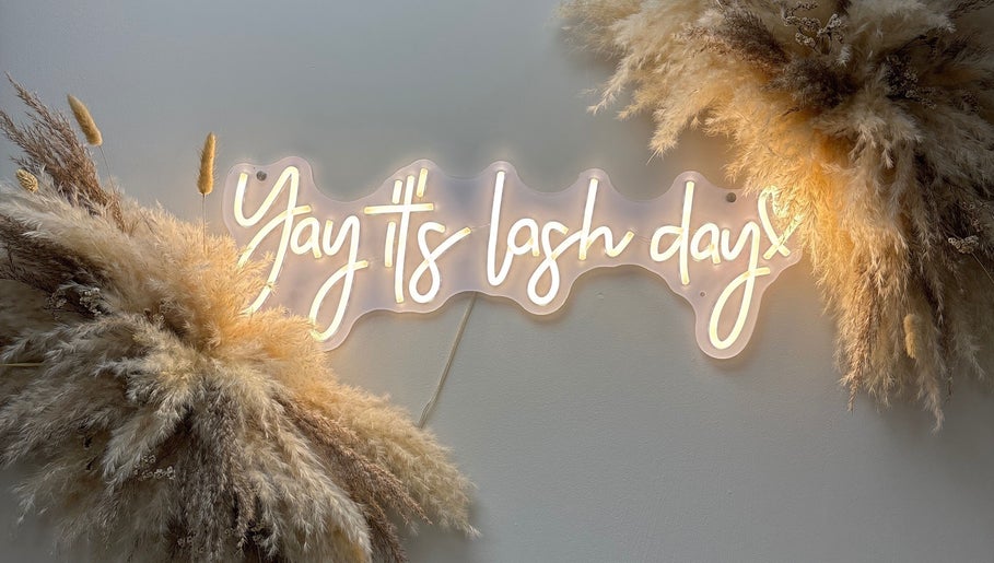 Neon sign saying 'Yay it's lash day' at Carly Mendes At Art House, Burnley, England, GB, with soft pampas decor.