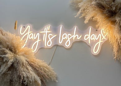 Neon sign saying 'Yay it's lash day' at Carly Mendes At Art House, Burnley, England, GB, with soft pampas decor.