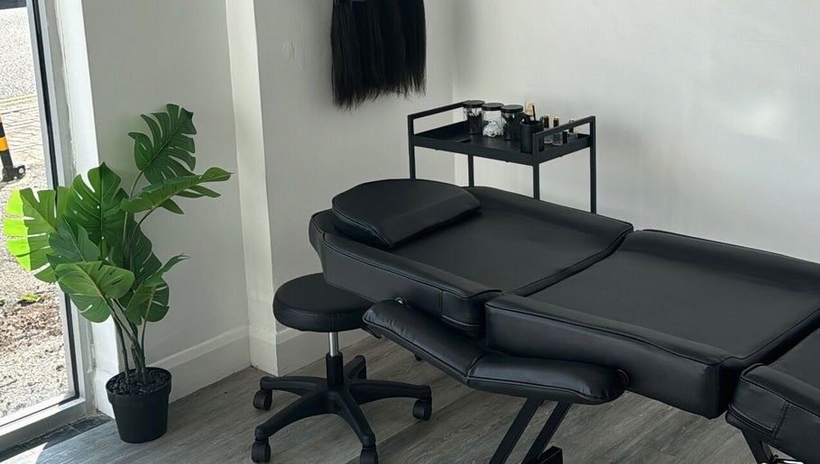 Elegant treatment room at Brooke Paris studios, London, England, GB, featuring black massage table and greenery.