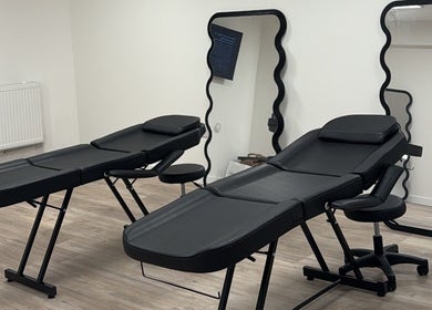 Modern treatment room at Brooke Paris Studios, London, England, GB, featuring sleek black massage tables.
