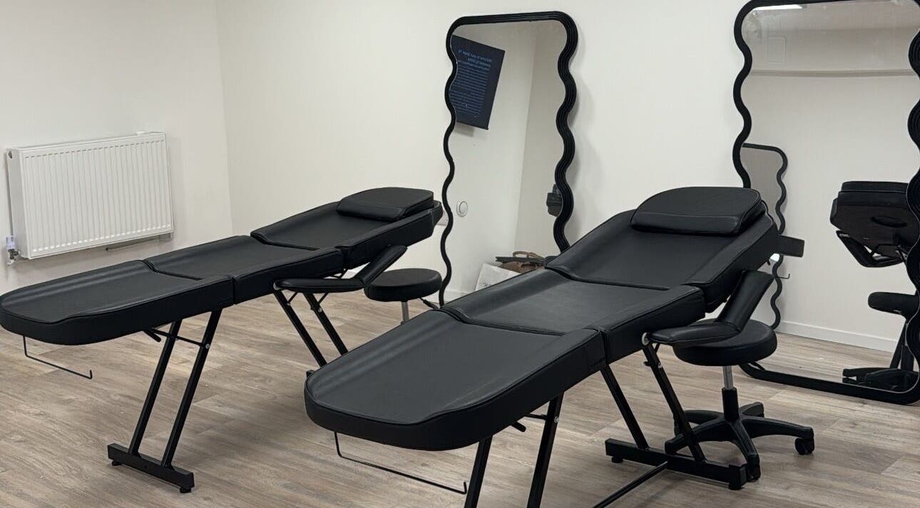 Modern treatment room at Brooke Paris Studios, London, England, GB, featuring sleek black massage tables.