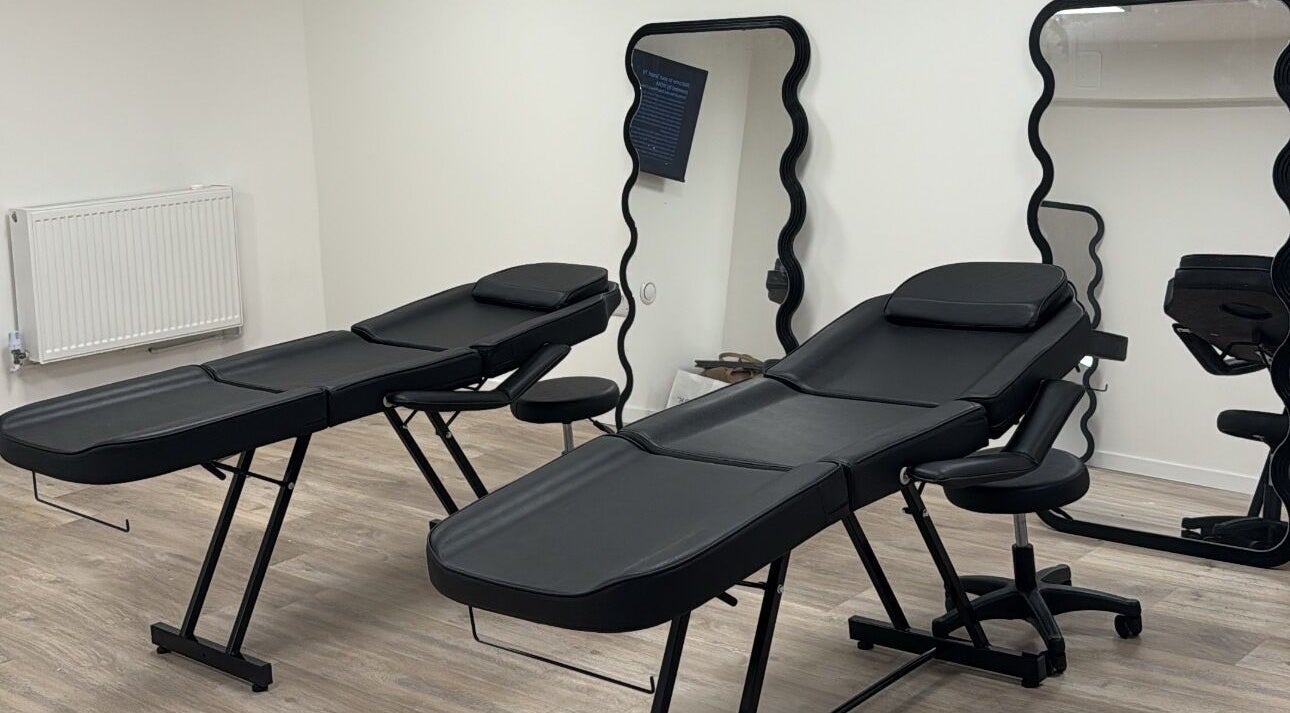 Modern treatment room at Brooke Paris Studios, London, England, GB, featuring sleek black massage tables.